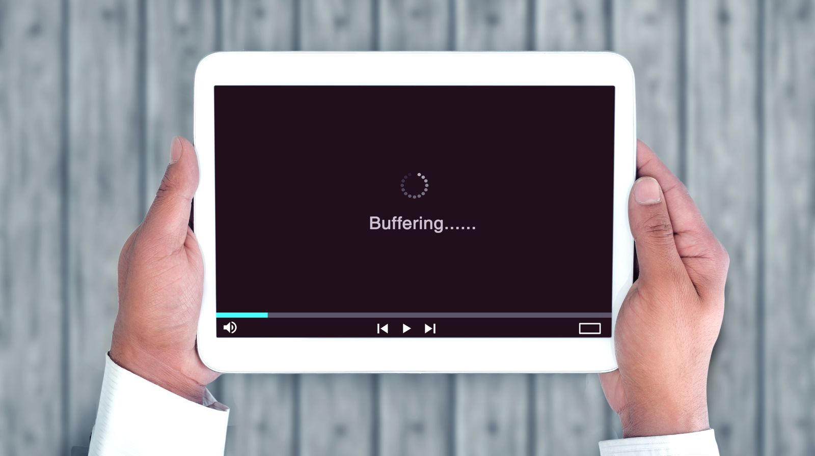Persona che guarda uno streaming video interrotto dal buffering su laptop, con simbolo di caricamento sullo schermo